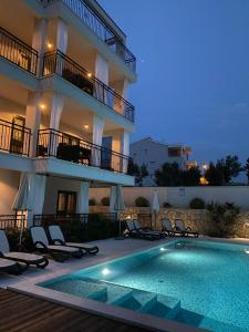 ein Hotel mit einem Swimmingpool vor einem Gebäude in der Unterkunft Baltimore.House in Baška Voda