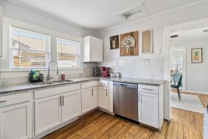 a kitchen with white cabinets and stainless steel appliances at Charming Bungalow in McKinney – Walk to Downtown bungalow in McKinney