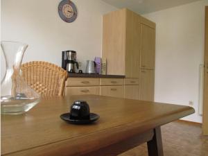 a wooden table with a glass vase and a clock at Ferienwohnung Bluhm in Weilheim in Oberbayern