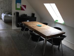 una sala da pranzo con tavolo e sedie in legno di Bagsværd Apartment a Hareskovby