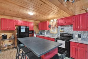 a kitchen with red cabinets and a black refrigerator at Hillside Hideaway cabin in Butler