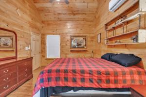 a bedroom with a bed in a wooden cabin at Hillside Hideaway cabin in Butler