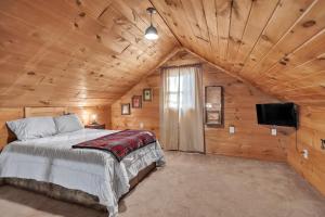a bedroom in a log cabin with a bed and a tv at Hillside Hideaway cabin in Butler