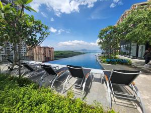 a group of chairs sitting next to a river at Urban Suites - Queens Suite in Jelutong