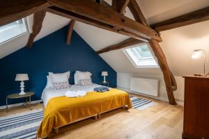 a bedroom with a yellow bed in a attic at Le Clos des Moriers 2 hours from Paris-Piscine-12 pers in Blois +52 photos