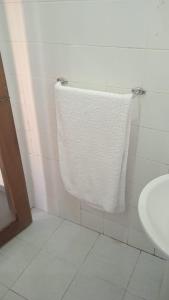 ein Bad mit einem weißen Handtuch an der Wand in der Unterkunft Refúgio Compacto in São Tomé