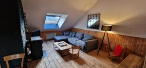 a living room with a couch and a table at Loft des Cimes - Evasion en montagne avec local vélo privé in Cornimont