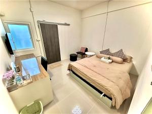 a small bedroom with a bed and a window at อมรรัตน์Room in Pathum Thani