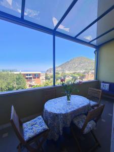 皮雅诺迪索伦托Casa Garofalo - De Vivo Realty Piano di Sorrento的桌子上摆放着椅子,花瓶上放着花