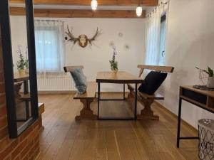 a living room with a table and benches and a window at Dom Pod Brzozą in Augustów