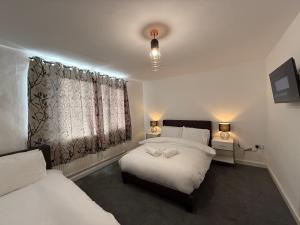 a bedroom with two beds and a window at Stunning 4-Bed House in Bridgend in Bridgend