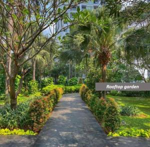 a walkway in a park with trees and bushes at Premium Getaway in City Central in Jakarta