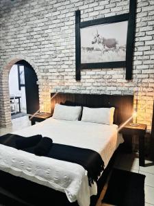 Un dormitorio con una cama grande y una pared de ladrillo. en The Wool House & Pablo's carolina, en Carolina 46 fotos más
