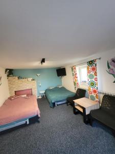 a hotel room with two beds and a couch at Apartamencik Pod Krokusem 2 in Rabka