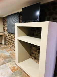 Un estante blanco con una TV encima. en The Wool House & Pablo's carolina, en Carolina