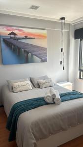 a bedroom with a large bed with a painting of a pier at Beach Apartment in Armação de Pêra