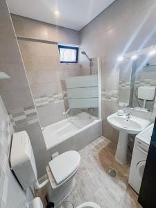a bathroom with a toilet and a tub and a sink at Beach Apartment in Armação de Pêra +46 photos