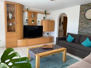 a living room with a couch and a tv at Sonnige Südwohnung mit Terrasse, Badesee in Forchtenberg