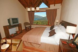 een slaapkamer met een groot bed en een raam bij Estancia Del Carmen Mountain Resort in Bariloche