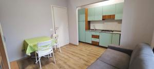 a living room with a table and a kitchen at Avilianum in Vigliano Biellese
