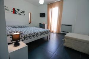 a bedroom with a bed and a couch and a window at Le Murge Del Salento Hotel b&b Depandance in Uggiano la Chiesa