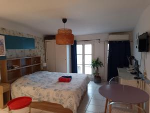 a bedroom with a bed and a table and a table at Studio cathédrale centre Aix-en-Provence in Aix-en-Provence