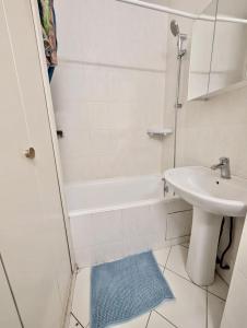 Un baño blanco con lavabo y ducha. en Spacious 80m2 Apartment - 8th Floor, Free Parking, Sleeps 5, en Grenoble 8 fotos más