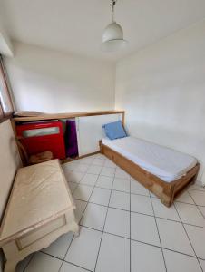 Habitación pequeña con cama y banco. en Spacious 80m2 Apartment - 8th Floor, Free Parking, Sleeps 5, en Grenoble