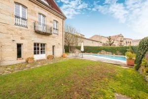 an exterior view of a house with a yard and a swimming pool at Casa Doña Blanca, Ourense in San Clodio