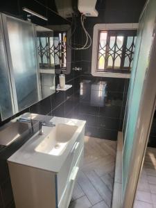 a bathroom with a white sink and a mirror at Viamo Lodge Apartments in Kumasi