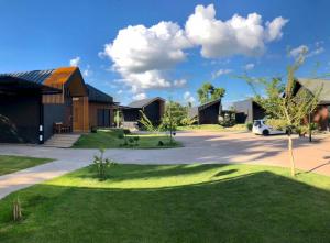 Ban Sam PhraoSleep@819 รีสอร์ท的车道和草地庭院的房子