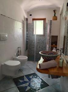 a bathroom with a toilet and a sink and a shower at Le pietre di Mario in Bari Sardo +17 photos