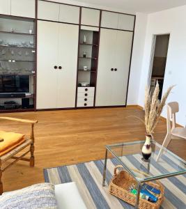 a living room with a glass table and white cabinets at Haus Grömitz Wohnung 15 in Grömitz