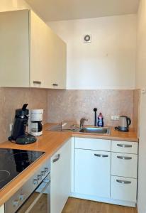 a kitchen with white cabinets and a sink at Haus Grömitz Wohnung 15 in Grömitz