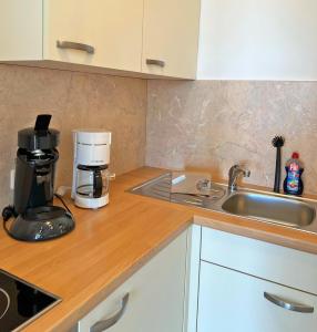 a kitchen counter with a coffee maker and a sink at Haus Grömitz Wohnung 15 in Grömitz +17 photos