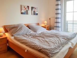 1 cama en un dormitorio con 2 lámparas y una ventana en FeWo Krüger 17, en Dahme