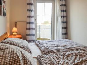 Un dormitorio con dos camas y una ventana. en FeWo Krüger 17, en Dahme 7 fotos más