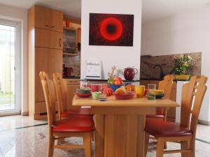 a kitchen with a wooden table and chairs with food on it at Villa am See in Göhren-Lebbin