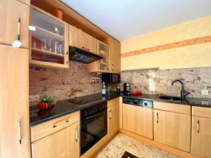 a kitchen with wooden cabinets and a sink at Villa am See in Göhren-Lebbin