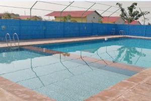 une piscine vide avec une clôture bleue dans l'établissement S K Pushkar Resort, à Pushkar