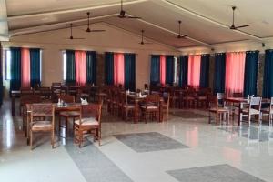 un restaurant avec des tables et des chaises en bois dans une salle dans l'établissement S K Pushkar Resort, à Pushkar