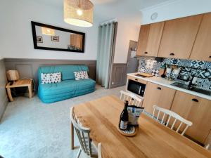 a living room with a table and a blue couch at L'Appart d'en face Casa Cosy in Le Pouliguen