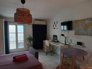 a living room with a table and a desk in a room at Studio cathédrale centre Aix-en-Provence in Aix-en-Provence
