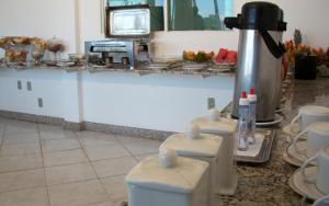 a kitchen with two toilets and a tv on a counter at Hotel Minas Brasil in Montes Claros