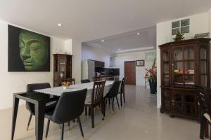 una cucina e una sala da pranzo con tavolo e sedie di Peaceful House in Rawai, Phuket a Phuket