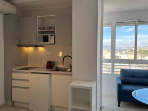 a kitchen with a sink and a microwave at Luceros 310 New in Alicante