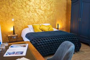 una camera da letto con un letto con cuscini gialli e un tavolo di Appartement cosy et chaleureux 6 personnes a La Baffe Altre 30 foto