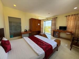 a bedroom with a large bed and a television at Ngũ Long Hai Hotel in Vĩnh Long