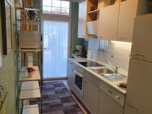 a kitchen with white cabinets and a sink at Ferienwohnung 1, unten in Bad Wilsnack