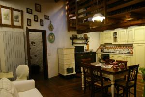 Il comprend une cuisine équipée d'une table, de chaises et d'une cuisinière. dans l'établissement Casa del Vasaio, à Tenno